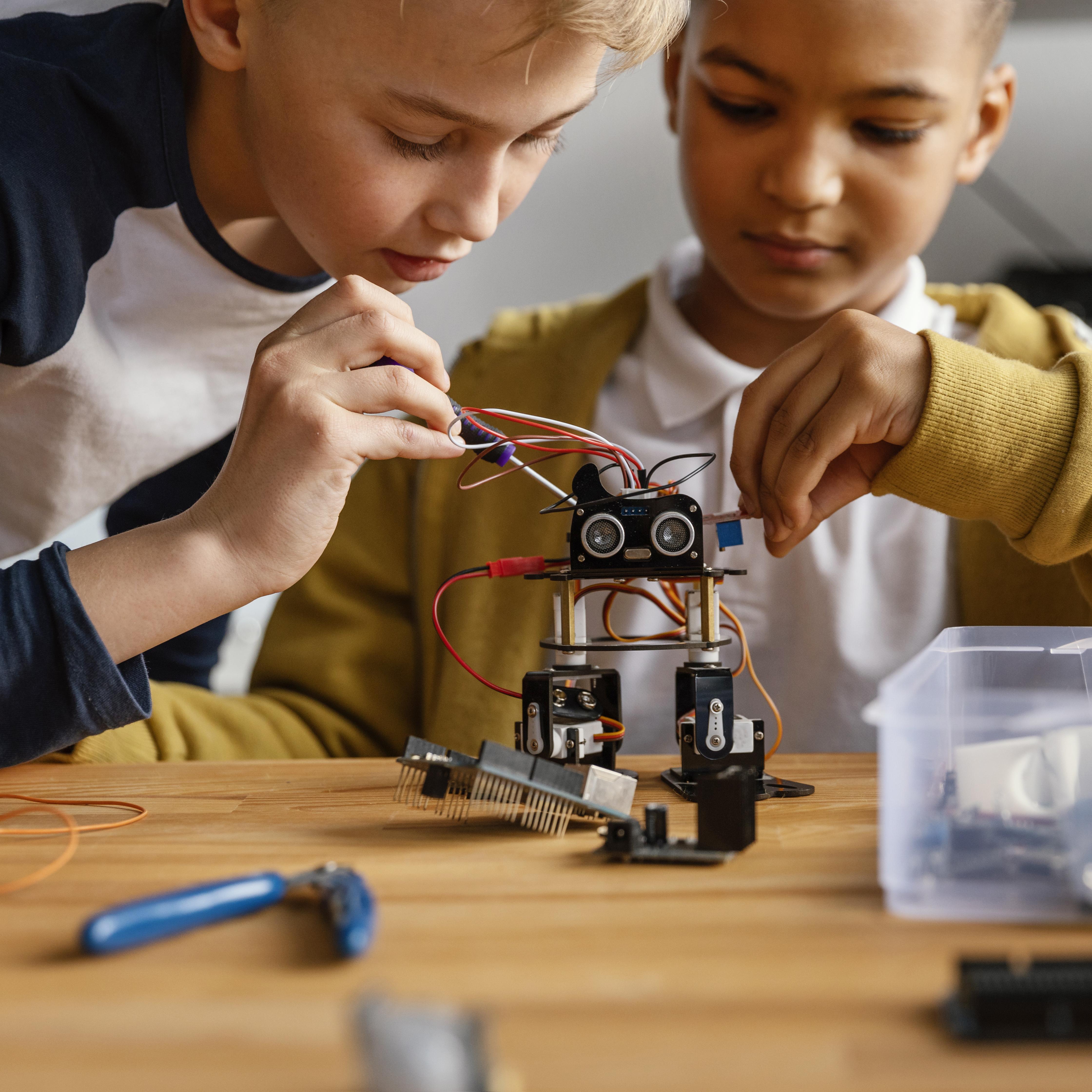 Header image: Student adjusting a robot prototype after an initial test run, showing persistence in STEM learning