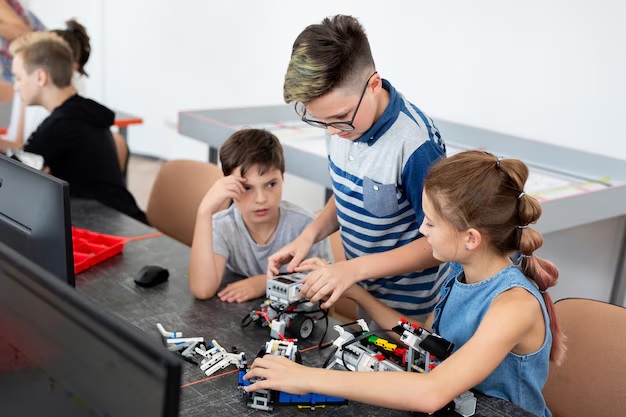 Photo: Small group of students collaborating on wiring a robot together